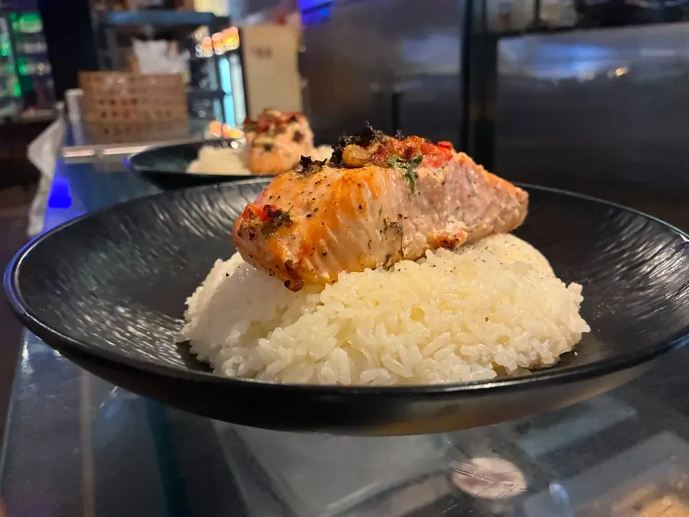 A salmon fillet over rice, finished with herbs